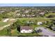 Aerial view showcases a home with a golf course, surrounded by trees and other residential homes at 1341 Marinella Dr, Palm Harbor, FL 34683