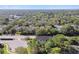 Aerial view of a home nestled among trees and a lake in the distance at 1341 Marinella Dr, Palm Harbor, FL 34683
