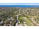An aerial view of a neighborhood near a golf course and bay, surrounded by lush trees at 1341 Marinella Dr, Palm Harbor, FL 34683