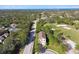 Aerial view of a home next to a golf course and a tree-lined street at 1341 Marinella Dr, Palm Harbor, FL 34683