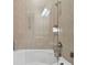 Modern bathroom features a luxurious soaking tub behind glass doors and tiled walls at 1341 Marinella Dr, Palm Harbor, FL 34683