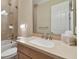Bathroom features a light countertop, a large framed mirror, and a door to the side at 1341 Marinella Dr, Palm Harbor, FL 34684