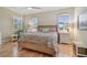 A stylish bedroom featuring two arched windows, a ceiling fan, and a comfy woven bedframe at 1341 Marinella Dr, Palm Harbor, FL 34683