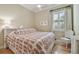 Comfortable bedroom with a large window, patterned bedding, and a decorative white chair at 1341 Marinella Dr, Palm Harbor, FL 34683