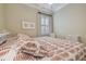 Bedroom featuring stylish patterned bedding, a ceiling fan and a bright window at 1341 Marinella Dr, Palm Harbor, FL 34683