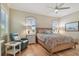 Bedroom with arched windows, ceiling fan, woven bedframe, and white nightstands at 1341 Marinella Dr, Palm Harbor, FL 34683