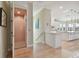 Hallway featuring a home elevator adjacent to an open kitchen with white cabinetry at 1341 Marinella Dr, Palm Harbor, FL 34683