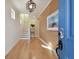 Bright entryway with hardwood floors, staircase, beach artwork, and a modern light fixture at 1341 Marinella Dr, Palm Harbor, FL 34683