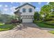 Charming two-story home with a brick driveway and well-manicured landscaping at 1341 Marinella Dr, Palm Harbor, FL 34683