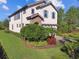 Charming two-story home with beautiful landscaping and a paver driveway, set against a blue sky at 1341 Marinella Dr, Palm Harbor, FL 34683