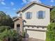 Charming home featuring a stone entryway, blue shutters, a brick driveway and an attached two-car garage at 1341 Marinella Dr, Palm Harbor, FL 34683