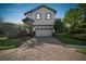 Charming two-story home with a brick driveway and well-manicured landscaping at 1341 Marinella Dr, Palm Harbor, FL 34683