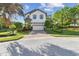 Beautiful two-story home with blue shutters, a two-car garage, and mature trees at 1341 Marinella Dr, Palm Harbor, FL 34683