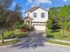 Charming two-story home with a brick driveway and vibrant landscaping at 1341 Marinella Dr, Palm Harbor, FL 34683