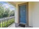 The home's blue front door features neutral trim, security hardware and porch at 1341 Marinella Dr, Palm Harbor, FL 34683