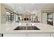 Kitchen island features stainless steel sink with open-concept view of the living area at 1341 Marinella Dr, Palm Harbor, FL 34683