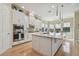 Bright kitchen features white cabinetry, stainless steel appliances, an island and wood flooring at 1341 Marinella Dr, Palm Harbor, FL 34684