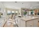 Bright kitchen shows large island with stainless steel dishwasher with eat-in breakfast area beyond at 1341 Marinella Dr, Palm Harbor, FL 34683