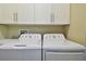 Clean laundry room features a washer, dryer, white cabinets, and utility sink at 1341 Marinella Dr, Palm Harbor, FL 34683