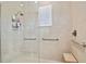 Shower with clear glass enclosure, integrated seat, and safety bars at 1341 Marinella Dr, Palm Harbor, FL 34683