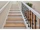Staircase with white risers and railings, complemented by decorative black spindles and wood treads at 1341 Marinella Dr, Palm Harbor, FL 34683