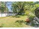 Expansive backyard featuring a lush lawn, privacy fence, and mature trees offering shade at 14903 Winterwind Dr, Tampa, FL 33624