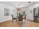 Dining area with table and seating next to kitchen with stainless refrigerator and stylish modern lighting at 14903 Winterwind Dr, Tampa, FL 33624