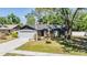 Charming single-story home featuring a gray exterior, well-manicured lawn, and mature shade trees at 14903 Winterwind Dr, Tampa, FL 33624
