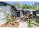 Inviting front entrance with decorative plants, a gray front door with oval window, and attractive landscaping at 14903 Winterwind Dr, Tampa, FL 33624