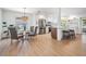 Open-concept kitchen with island seating flows to the dining area with modern lighting and stainless steel refrigerator at 14903 Winterwind Dr, Tampa, FL 33624