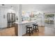 Bright, updated kitchen with stainless steel appliances, modern lighting, and bar seating overlooking outdoor patio at 14903 Winterwind Dr, Tampa, FL 33624