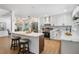 Open kitchen with stainless appliances, light countertops, island with seating, and stylish pendant lighting at 14903 Winterwind Dr, Tampa, FL 33624