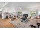 Well-lit living area with wood floors, a fireplace, modern furniture, and an open layout to the kitchen at 14903 Winterwind Dr, Tampa, FL 33624