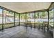 Screened porch with tile flooring provides a relaxing outdoor living space with views of the backyard at 14903 Winterwind Dr, Tampa, FL 33624