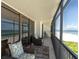 Condo balcony with chairs, table, and rug overlooking a sandy beach and the ocean at 15400 Gulf Blvd # 202, Madeira Beach, FL 33708