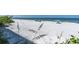Wide sandy beach with vegetation and scattered beachgoers enjoying the sunny weather at 15400 Gulf Blvd # 202, Madeira Beach, FL 33708