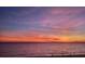 Scenic beach view with a pink and orange sunset and people walking along the shoreline at 15400 Gulf Blvd # 202, Madeira Beach, FL 33708
