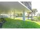 Exterior of condo building with large grass lawn and view of nearby landscaping at 15400 Gulf Blvd # 202, Madeira Beach, FL 33708