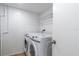 Efficient laundry area featuring modern white washer and dryer units with storage shelves at 15400 Gulf Blvd # 202, Madeira Beach, FL 33708