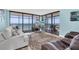 Bright living room with ocean views from floor to ceiling windows and a decorative palm rug at 15400 Gulf Blvd # 202, Madeira Beach, FL 33708