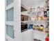 Organized pantry with shelving, storage baskets, and a built-in microwave for easy access at 15400 Gulf Blvd # 202, Madeira Beach, FL 33708