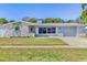 Charming single-story home featuring a well-manicured lawn, and a light blue exterior color scheme at 1560 Simmons Dr, Clearwater, FL 33756