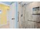 Bathroom featuring tiled shower, grab bars, and tiled floors at 1560 Simmons Dr, Clearwater, FL 33756