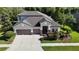 Aerial view of a well-manicured two-story home with three-car garage and complementing landscape at 15625 Hawks Crest Loop, Odessa, FL 33556