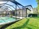 Tranquil backyard with a refreshing pool, screened enclosure, and well-maintained lawn, perfect for outdoor enjoyment at 15625 Hawks Crest Loop, Odessa, FL 33556