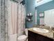 Well-lit bathroom with granite countertop, sink, and floral shower curtain at 15625 Hawks Crest Loop, Odessa, FL 33556