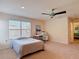 Cozy bedroom with a ceiling fan, a large window for natural light, and a desk area, perfect for work or study at 15625 Hawks Crest Loop, Odessa, FL 33556