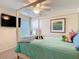Inviting bedroom features a four-poster bed, TV, and window bringing comfort and style to the space at 15625 Hawks Crest Loop, Odessa, FL 33556