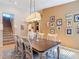 Inviting dining room with a long table, chandelier, decor, and access to the staircase and kitchen at 15625 Hawks Crest Loop, Odessa, FL 33556