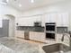 Open kitchen featuring white cabinets, stainless appliances, a wine cooler, and light-toned countertops at 15625 Hawks Crest Loop, Odessa, FL 33556